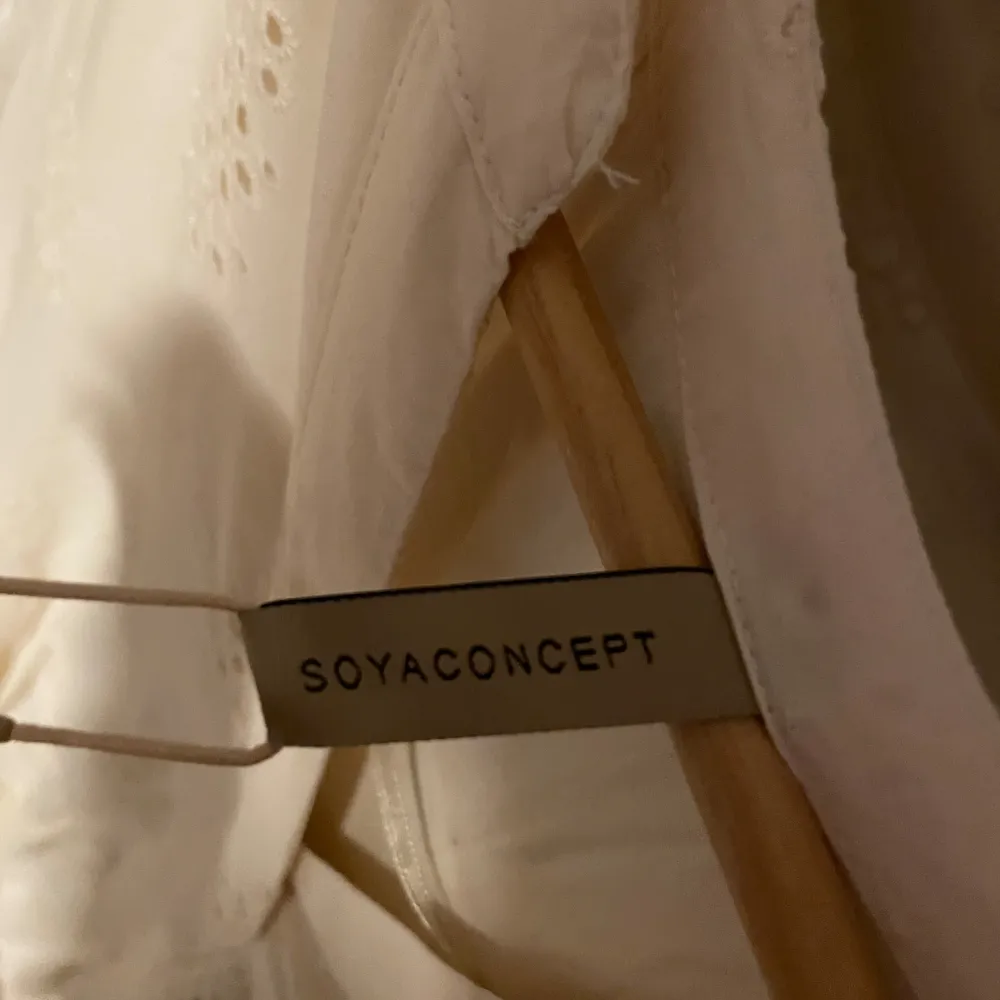 Säljer en söt beige klänning från Soyaconcept med korta ärmar och v-ringning. Klänningen har ett fint broderat mönster, ny med prislapp. Mekot.