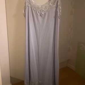 Nattlinne - Ljusblått nattlinne med vackra spetsdetaljer vid halsringningen och fållen. Klänningen har smala axelband som går att justera och har jätteskönt silkes material!