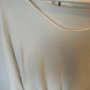 Vit stickad tröja - Säljer en stilren vit stickad tröja med lång ärm och rund hals. Köpt på mitt tidigare jobb därav har den ingen märkning eller specifik storlek. Men  nopprar aldrig av sig och är väldigt skön! Säljer likadan i 2 till färger (beige och aprikos)