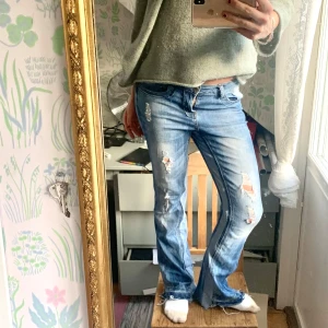 Lågmidjade slitna jeans - Snygga blå lowwaist bootcut jeans med slitna detaljer som jag sytt ut själv vilket ger en väldigt trendig style. 