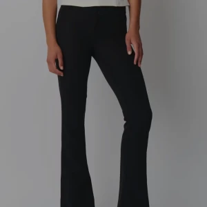 Svarta bootcut kostymbyxor  - Snygga svarta bootcut kostymbyxor med låg midja. Byxorna har en stilren design med knappar bak och en tight passform som framhäver figuren. Perfekta för en trendig look. Helt oanvända, lapparna kvar.