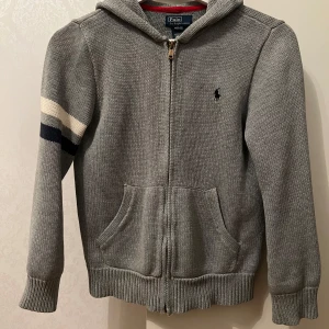 Polo Ralph Lauren zip hoddie - Säljer en stilren grå hoodie från Polo Ralph Lauren med dragkedja och huva. Storlek M (10-12). Jättefin 