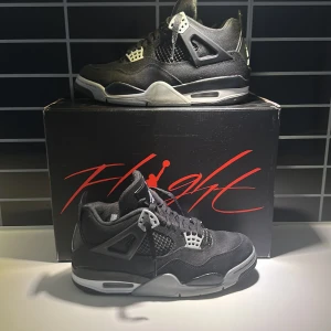 Jordan 4 Retro SE  - Snygga svarta Nike Air Jordans med grå och röda detaljer. Skorna har en klassisk design med snörning och den ikoniska Jumpman-loggan. Perfekta för dig som vill ha stil och komfort i ett. Storlek 40 