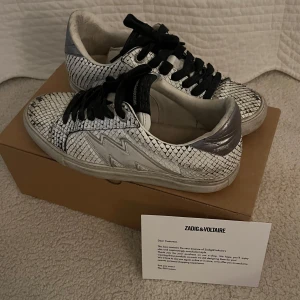  sneakers från Zadig & Voltaire - Snygga sneakers från Zadig & Voltaire med ett orm mönster. Allt i bilden är inkl. Använt dem flitigt därav priset. Men dem är fortfarande i fin skick! Köpte för ca 3000kr och pris kan diskuteras