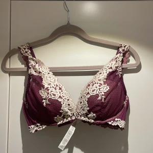 Intimissimi BH - Elegant lila bh med vackra spetsdetaljer i vit från Intimissimi. Den har breda axelband och en djup v-ringning som ger en feminin touch. Perfekt för att känna sig extra fin under kläderna. Som ny