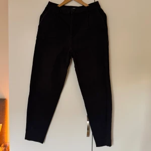 Svarta byxor med knappstängning - Snygga svarta byxor/jeans med  fickor både fram och bak. Strl 38 (S)