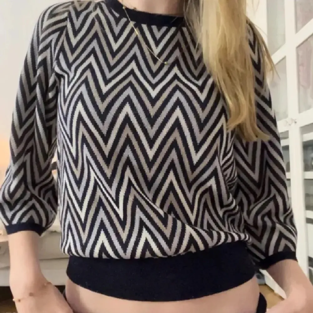 Säljer en snygg svartvit tröja med zigzag-mönster. Tröjan har trekvartsärmar och en rund halsringning. Perfekt för en trendig look!. Neuletakit & Villapaidat.
