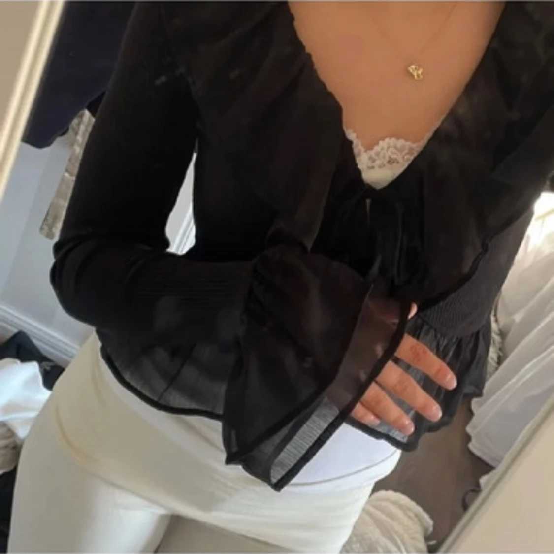 Svart blus med volangdetaljer