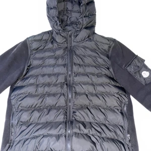 Svart pufferjacka med huva - Säljer en stilren svart pufferjacka från Moncler. Jackan har en praktisk huva och dragkedja framtill. Den är perfekt för kyligare dagar och har en modern design med quiltade detaljer. Passar bra för både vardag och utomhusaktiviteter.