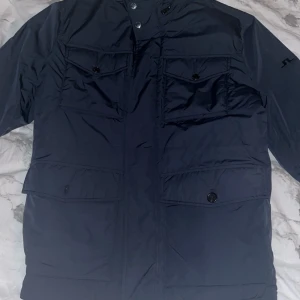 Mörkblå jacka från J.Lindeberg - Snygg sprillans ny jacka från J.Lindeberg. Jackan är aldrig använd å köpt för 4200kr. Perfekt för den som söker stil i vardagen.
