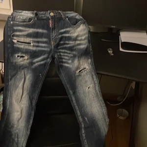 Blå jeans från Dsquared2 - Snygga blå jeans från Dsquared2 med slitna detaljer och en cool tvätt. De har en klassisk femficksdesign och knappgylf. Perfekta för en avslappnad stil med en touch av edge.