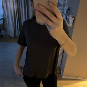 Svart t-shirt - En enkel och stilren svart t-shirt med normal passform. Perfekt för en avslappnad look. Träningtröja.