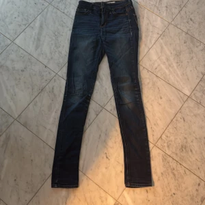 Hollister jeans  - Snygga blå jeans från Hollister med klassisk femficksdesign och kontrastsömmar. De har en smal passform och är perfekta för en avslappnad stil. Jeansen har en dragkedja och knapp framtill. Använda ett fåtal gånger. 