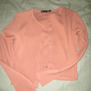 Rosa kofta från Lager 157 - Säljer en söt rosa kofta från Lager 157. Den har långa ärmar och knappar framtill. Perfekt för lager-på-lager under kyligare dagar. Passar till både jeans och kjol!