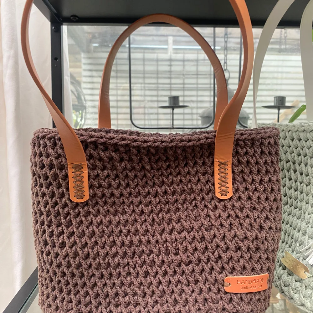 Säljer en superfin brun virkad väska. Den har snygga läderhandtag och en stabil botten med små metallfötter. Perfekt för höstshopping eller som en chic vardagsväska. 👜. Laukut & Käsilaukut.