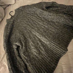 Grå stickad tröja från H&M Divided - Säljer en supermysig grå stickad tröja som ja fått i julklapp, perfekt för kyliga dagar. Tröjan har långa ärmar och en skön passform som håller dig varm hela vintern. Tröjan är oversized så den passar även till typ M. Aldrig använd