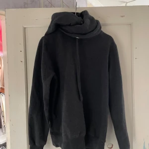 Mörkgrå hoodie från Fabilion - Säljer en supermysig mörkgrå hoodie från Fabilion. Den har en stor och skön krage med dragsko och långa ärmar. Perfekt för kyliga dagar när du vill vara både bekväm och stilren. Passar perfekt till höst och vinter!