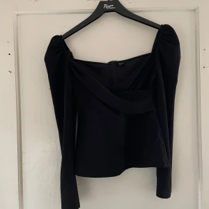 Svart offshoulder topp från Shein - Säljer en elegant svart offshoulder topp från Shein i storlek XS. Toppen har långa ärmar och en dragkedja i ryggen för en smidig passform. Perfekt för en utekväll eller fest! 🖤