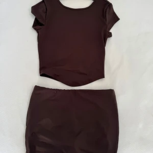 Set - Brunt sett, tröjan är öppen i ryggen och kjolen har shorts inbyggt! 