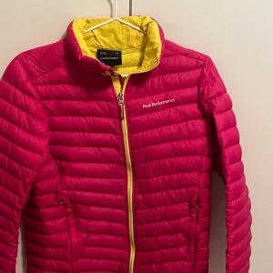 Rosa dunjacka från Peak Performance - Säljer en superfin rosa dunjacka från Peak Performance. Använd ett fåtal gånger så i mycket bra skick. Egentligen i barn storlek (160) men skulle säga att den sitter som en Xs-S.