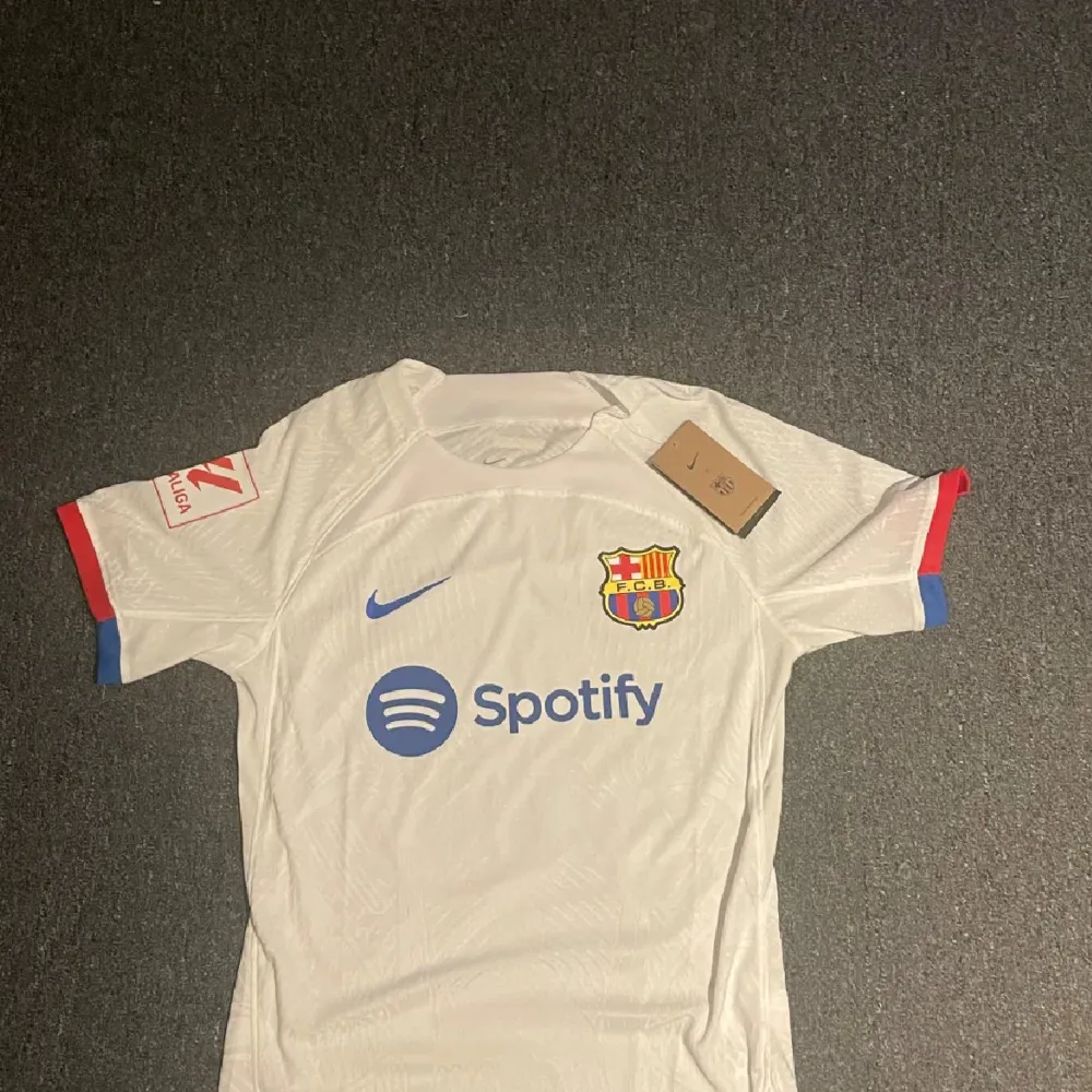 Säljer min Barca tröja då den inte kommer till användning och är i toppskick. Tröjan är en palyer edition och användes säsongen 23/24 och är deras borta tröja. . T-shirts.