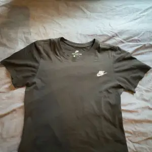 Säljer en svart t-shirt från Nike i storlek S. Den är i bomull och har en broderad Nike-logga på bröstet. Perfekt för vardagsbruk eller träning. T-shirten är i nyskick och har en normal passform. Passar både vår och sommar.