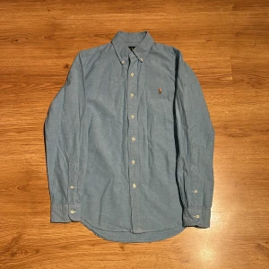 Ralph Lauren Skjorta  - Ljusblåa skjorta ifrån Ralph Lauren i storlek S, mycket bra skick och den är som ny utan några skador eller fläckar. Nypris ca 1600kr men säljer den för endast 400kr men det kan diskuteras innan affär. Kom DM vid fler frågor eller bilder på skjortan!