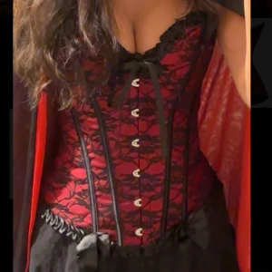 Rödsvart korsett - Säljer den här supersnygga korsetten som passar perfekt till halloween! Aldrig använd endast testad en gång och går att justera till strl S och M! Vid frågor är d bara o kontakta💕💕