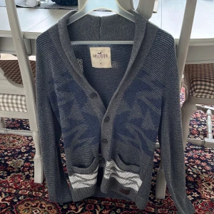 Hollister cardigan - Säljer nu denna otroligt feta och eftertraktade cardiganen från hollister, skick 9/10 och är k storlek M, riktigt bra pris!