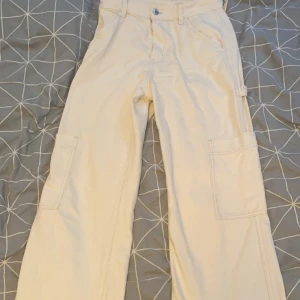 Jeans - Par vita raka högmidjade jeans med fickor på benen. Använda ett fåtal gånger och inga tecken på slitage. Älskar verkligen dessa byxor tycker dom är jätte snygga men måste tyvärr sälja dom på grund av att de blivit försmå. 