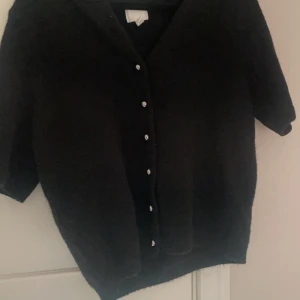 kortärmad kofta - Svart kofta med silver knappar från Hm! Kortärmad kofta i storlek S och i nyskick. Helt oanvänd. Säljer eftersom den inte kommer till användning🫶