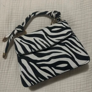 Väska zebra design - Säljer min väska i zebra design, oanvänd. Rep medföljer. Köpt för 299kr.