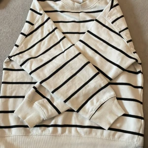 Randig tjocktröja - Jätte fin vit svart randig tröja, säljer eftersom den blivit för liten❤️liten fläck men går att tvätta bort, pytte lite nopprig men man tänker inte på det. Köpt för 180kr säljer för 50kr. Frakt kan diskuteras