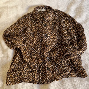Brun-prickig hope skjorta  - Brun-prickig hope skjorta med fickor på framsidan, är ca 160 cm för referens 