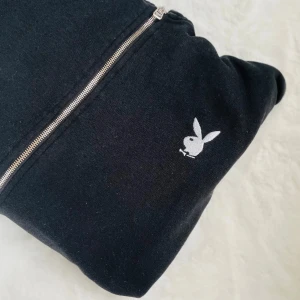 Playboy ziptröja - Säljer en svart Playboy luvtröja med zip. Finns tryck både på ena ärmen och på ryggen. Använd fåtal gånger så i fint skick. Köpt på Missguided x Playboy. Säljer billigt istället för att den slängs👄