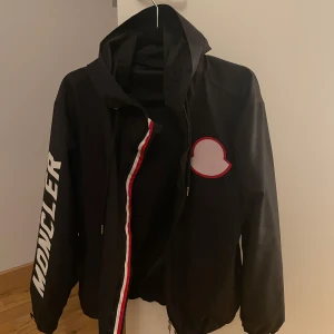 Moncler regn/vind jacka - Äkta moncler regn/vind jacka köpt i berlin för ca 3 år sedan men är i väldigt bra skick inga skador. Limited edition för fler bilder och frågor kontakta mig.