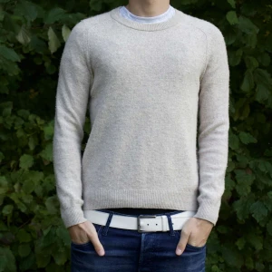 Beige stickad tröja - Säljer en supermysig beige stickad tröja som är perfekt för kyliga dagar. Den har en klassisk rund hals och långa ärmar. Tröjan är i bra skick och passar perfekt till både vardag och lite finare tillfällen. Perfekt för höst och vinter! Passar S