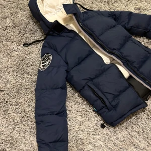 dBrand dunjacka - Vinterjacka från dBrand. I nyskick, endast använd 1 säsong och väl omhändertagen.  Jättevarm och skön fluffig jacka i storlek XS. Färg mörkblå. Köpt för 2495kr från Nelly. 