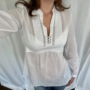 Knyttopp - Vit långärmad topp från Blossom i 100% bomull. Knyts i ryggen 💘