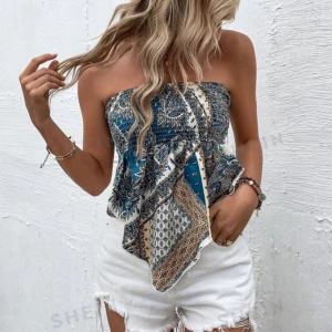 Mönstrad tubtopp med knyt - Nypris 69kr, aldrig använd endast testad.             Säljer denna superfina mönstrad tubtopp i blått och beige med paisley-mönster. Toppen är axelbandslös och har en snygg knytning i ryggen. 