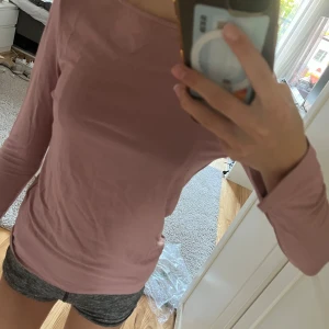 Rosa långärmad tröja - Säljer en superfin rosa långärmad tröja. Den är perfekt för både vardag och mysiga hemmakvällar. Tröjan har en enkel och stilren design, vilket gör den lätt att matcha med olika outfits. Den är i bra skick och väldigt bekväm att ha på sig.