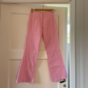Rosa bootcut jeans - Ljusrosa bootcut jeans med snygga sömmar längst med benen. Köpta på second-hand-butiken Siv och Åke i Sthlm. Kommer inte till användning längre. Storlek 34/XS. Ser ut som nya!