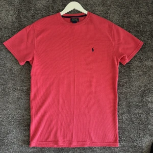 Röd t-shirt från Polo Ralph Lauren - Säljer en snygg röd t-shirt från Polo Ralph Lauren. Den är gjord i 100% bomull och har en klassisk passform. T-shirten har en liten broderad logga på bröstet och är perfekt för både vardag och fest. Skicka ett meddelande om du är intresserad!