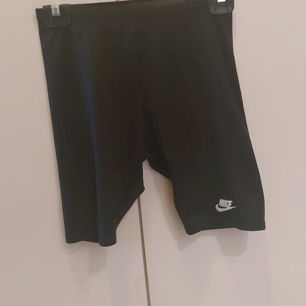 Säljer ett par svarta träningsshorts från Nike i storlek M. De är perfekta för gymmet eller löprundan. Shortsen har en enkel design med Nike-loggan på benet. De är bekväma och har en normal passform.. Shorts.