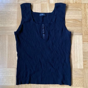 Svart ribbad topp från Rossner - Svart ribbat linne från Rossner med knappar framtill!