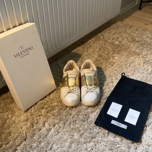 Valentinos opens guld  - Skorna är i använt skick och köpt här på Plick. Dustbag, äkthetsvevis och kartongen medföljer! Skriv privat för fler frågor. 