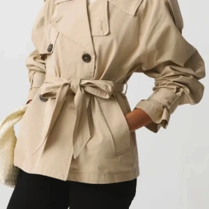 Beige trenchcoat med knytband - Snygg beige trenchcoat med knytband i midjan och stora knappar framtill. Jackan har långa ärmar och en klassisk krage. Perfekt för en stilren look. Jackan köptes ifrån ginatricot för 700kr och säljs nu för 400kr. Storlek xss men passar för dig som normalt är xs/s. 
