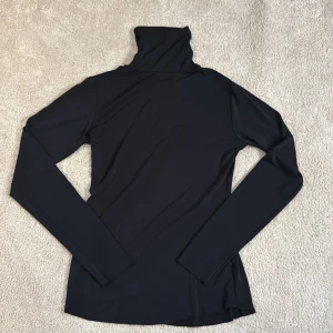 Svart polotröja från Lindex - Säljer en stilren svart polotröja från Lindex. Tröjan är långärmad men har ett tunt material, vilket är perfekt nu till våren.🌸Den är även lite genomskinlig pga materialet. Den enda defekten är en liten fläck på armen, men tror det går bort i tvätten. Säljer eftersom att den inte används.💕