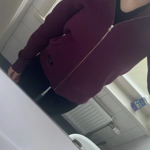 Vinröd vinted zip-up från Peak Performance - Säljer en snygg vinröd hoodie från Peak Performance. Den har en dragkedja framtill och praktiska fickor. Perfekt för kyliga dagar och ger en avslappnad stil. Passar bra till jeans eller träningsbyxor. Säljer då jag inte använder den längre men vill att någon annan ska njuta av den. 
