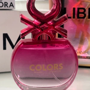Rosa parfymflaska från Colors - Snygg och modern parfymflaska i en djup rosa nyans från Colors. Flaskan har en unik design med en dekorativ topp och guldtext på framsidan. Perfekt för den som vill ha en färgglad och stilren doft på hyllan.